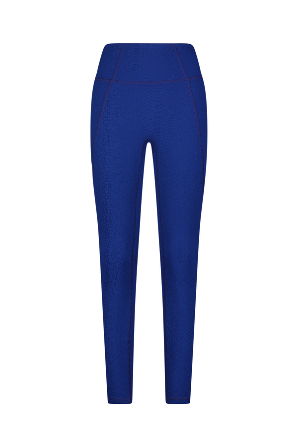 The Ava Legging by Gigi C Sport features a textured compression waffle jacquard and visible seam detailing. These blue, high-waist, fitted, full-length leggings are displayed against a plain white background to highlight their sleek design.