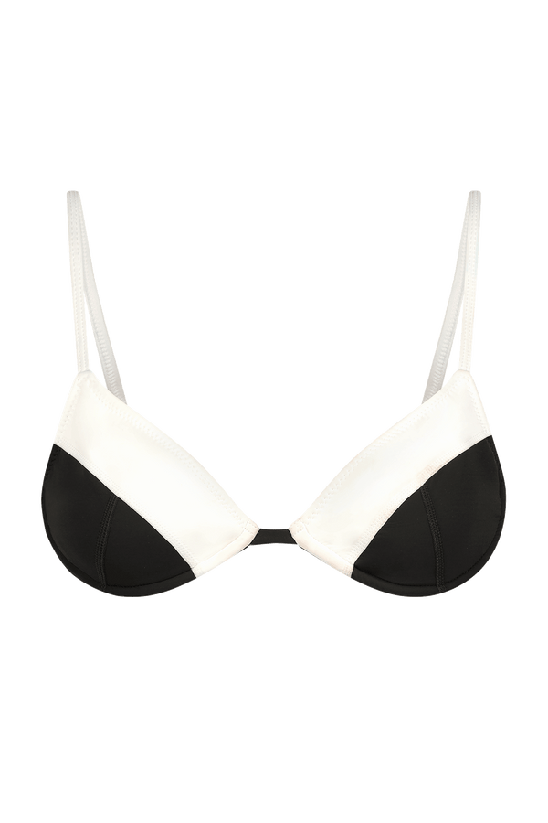 The Emerson Top by Gigi C Bikinis is a chic black and white triangle bikini top with adjustable thin straps. It features a sleek, modern color-blocking design with diagonal sections on each cup.
