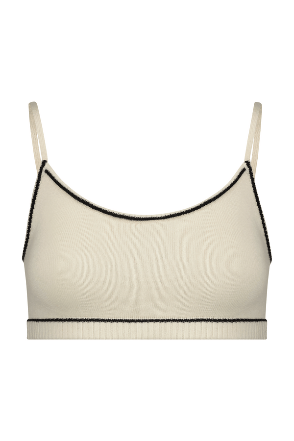 The Danica Bralette by Gigi C Lounge is a cream-colored crop top with thin straps and black trim. Made from a wool-cashmere blend, its ribbed fabric offers luxurious texture and minimalist style.