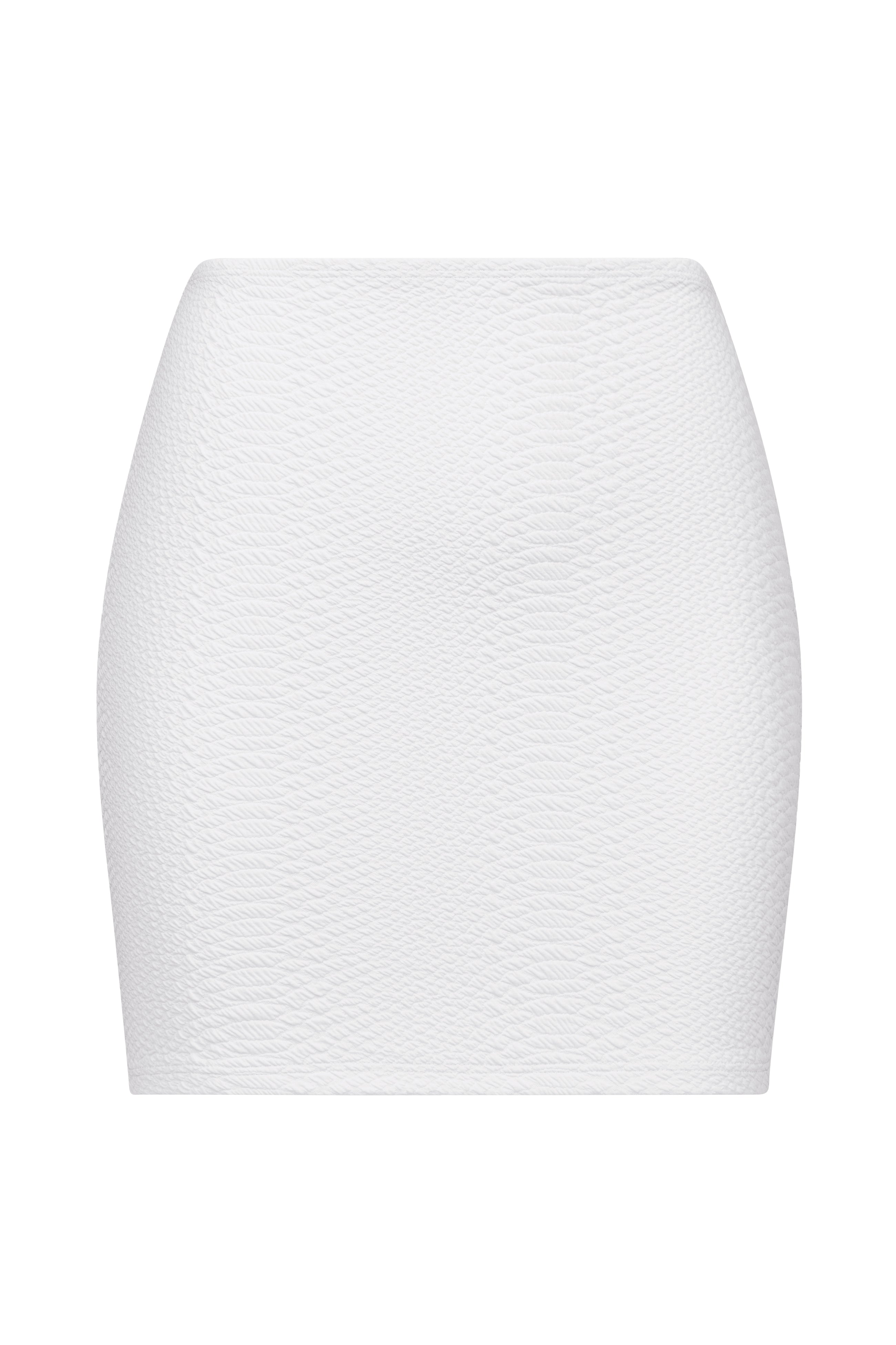 The Joelle Skirt by Gigi C Bikinis is a white, textured mini skirt with a fitted silhouette. It features bi-stretch compression for comfort, and its subtly patterned fabric adds visual interest against a plain white background.