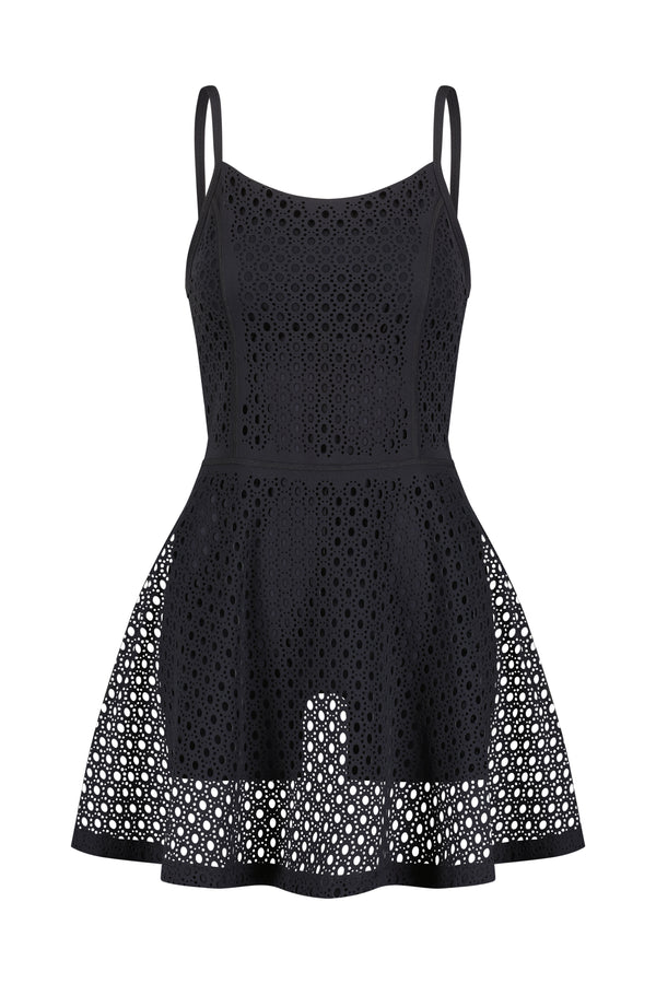 Introducing Gigi C Sports Lennox Dress: a black sleeveless design with thin straps and an A-line silhouette. It features a mesh overlay with circular cutout patterns for a chic semi-transparent look, perfect for any occasion.