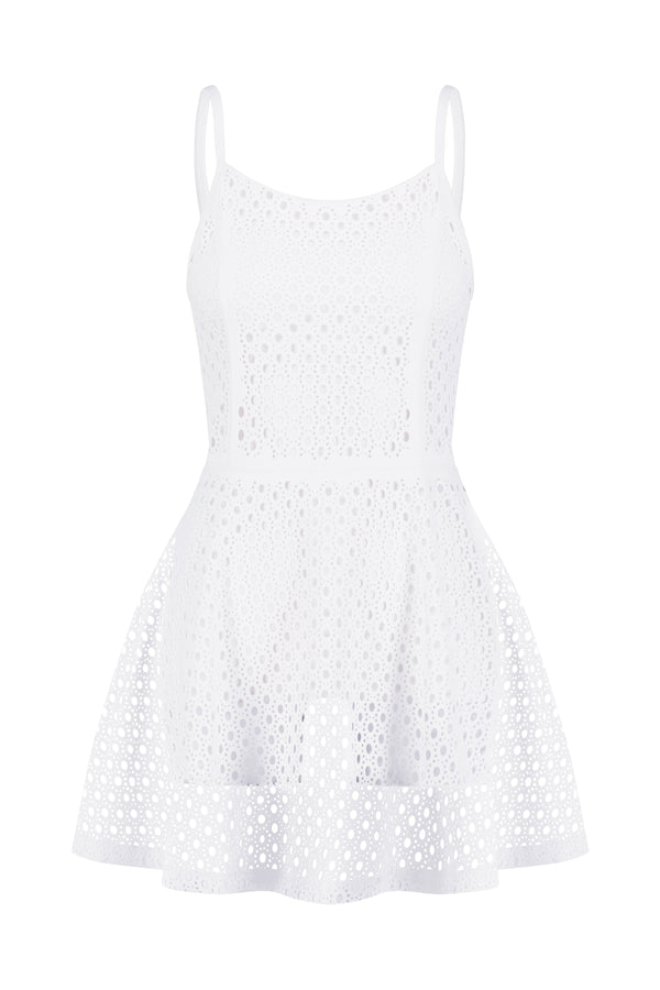 The Lennox Dress by Gigi C Sport is a sleeveless white piece with spaghetti straps and a flared skirt. Crafted from stretch fabric, it has a perforated design with circular cutouts, offering texture and an airy feel ideal for blending athleisure style with elegance.