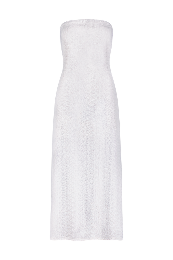 Discover the Maya Dress by Gigi C Bikinis: a strapless white dress in textured faux snake fabric. Its tridimensional elasticity offers a sleek, form-fitting mid-length silhouette, embodying elegance against a black background.
