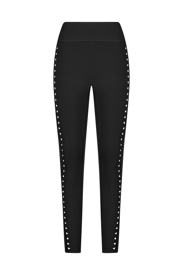Introducing the Katrina Legging from Gigi C Sport: Black high-waist, slim-fit leggings with heart-shaped white studs on the sides. Crafted with seamless compression fabric, these leggings offer a sleek look without visible logos or patterns.