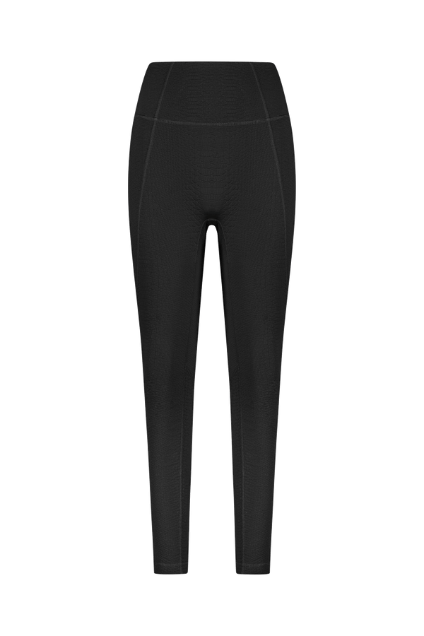 A black Ava Legging by Gigi C Sport is displayed on a white background, showcasing its sleek, fitted design with faint stitching near the waist and sides. Made from bi-stretch compression waffle jacquard fabric, it enhances the athletic look.