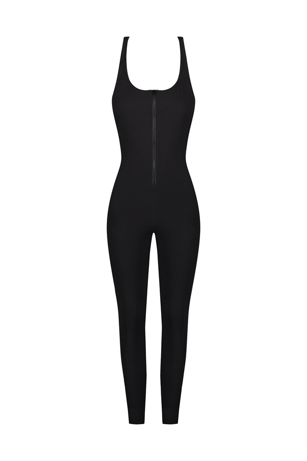 The Merit Jumpsuit by Gigi C Sport showcases a black textured, body-hugging design with a faux snake jacquard pattern. It features a sleeveless style, scoop neckline, and front zipper, offering bi-stretch compression for comfort and full-length legs against a plain white background.