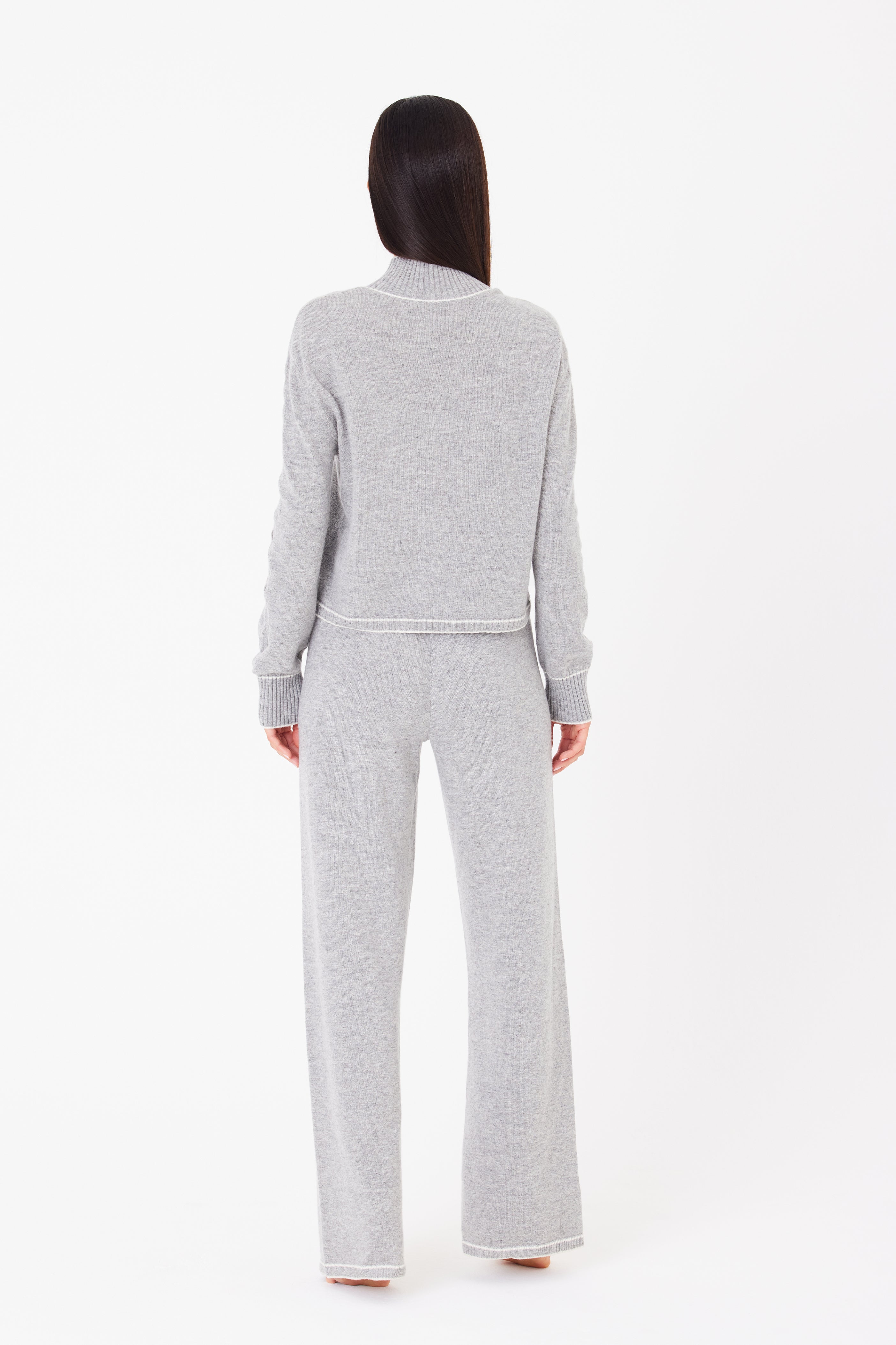 Rear view of someone with long dark hair embracing après-ski elegance in a gray knit sweater and matching Aubrie Wide Leg Pant by Gigi C Lounge, crafted from a luxurious wool cashmere blend, against a plain white background.
